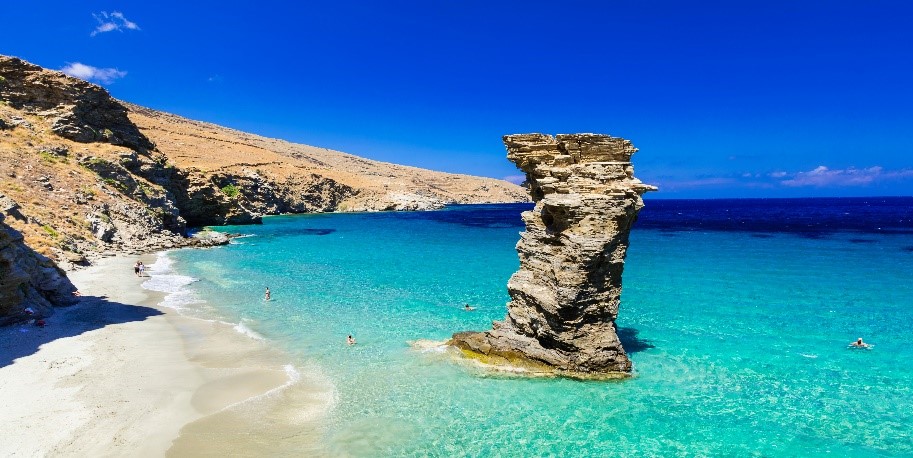 Plage d'Andros avec rocher dans l'eau dans les Cyclades en Grèce
